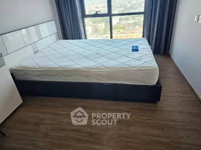 Spacious bedroom with large window offering stunning city views, featuring a modern bed and elegant flooring.