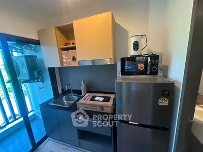Modern compact kitchen with sleek appliances and balcony view