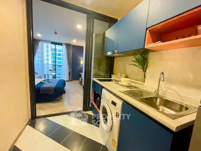 Modern apartment with compact kitchen and cozy bedroom view