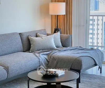 Modern living room with cozy gray sofa and stylish decor near balcony.