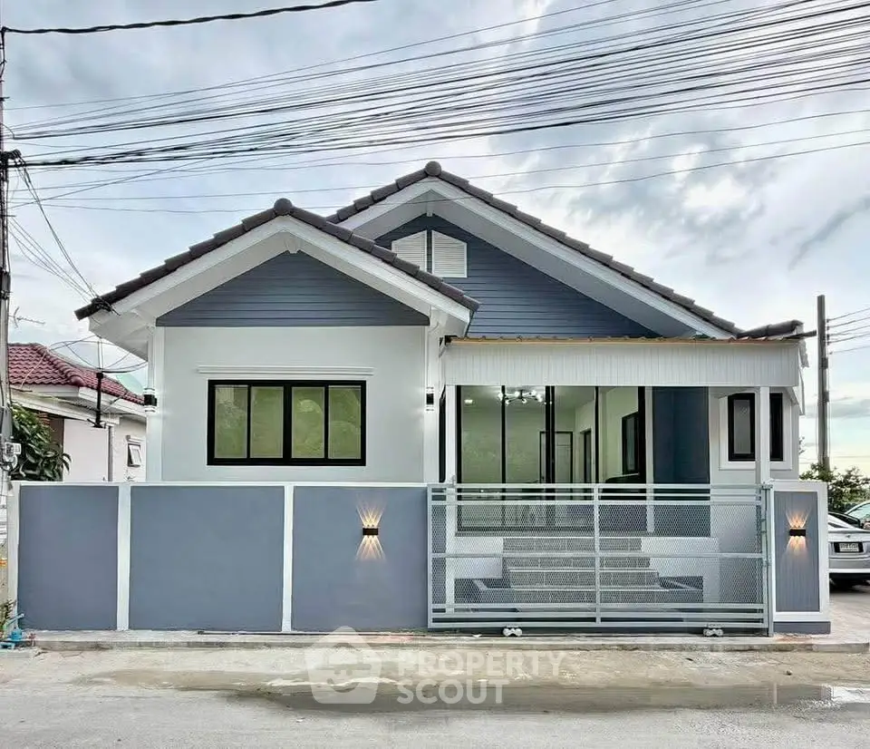 Charming single-story house with modern facade and gated entrance, perfect for family living.
