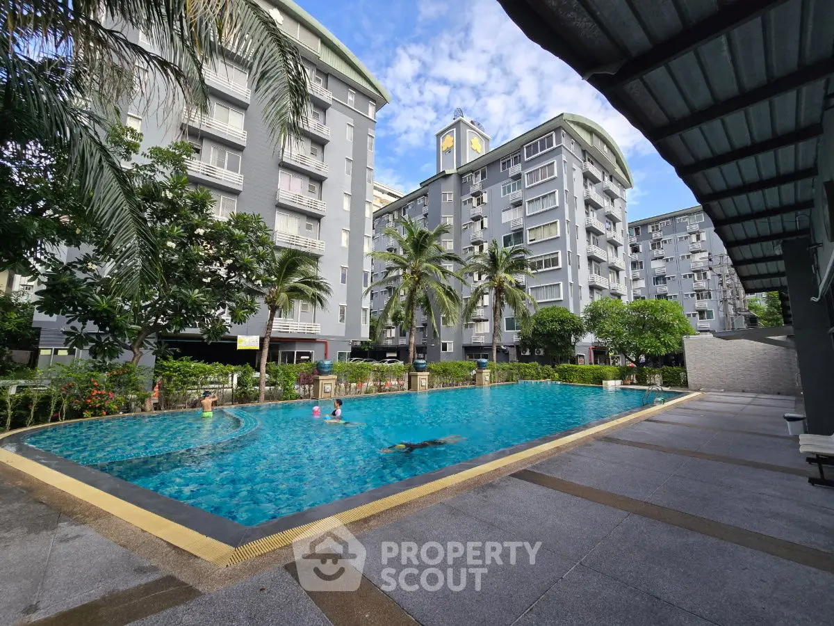 Luxurious residential complex with a sparkling pool and lush greenery, perfect for modern living.