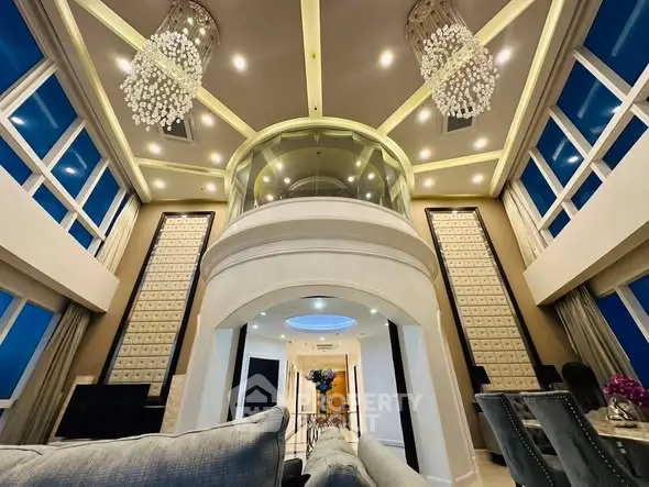 Luxurious high-ceiling living room with elegant chandeliers and modern design.