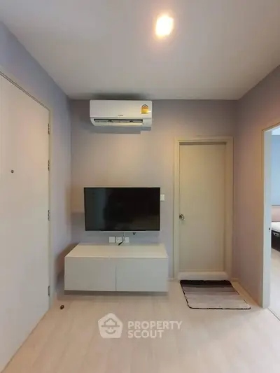 Modern living room with air conditioning and wall-mounted TV in a cozy apartment.