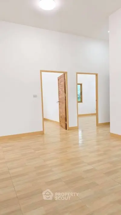 Spacious interior with wooden flooring and open doorways in a modern home.