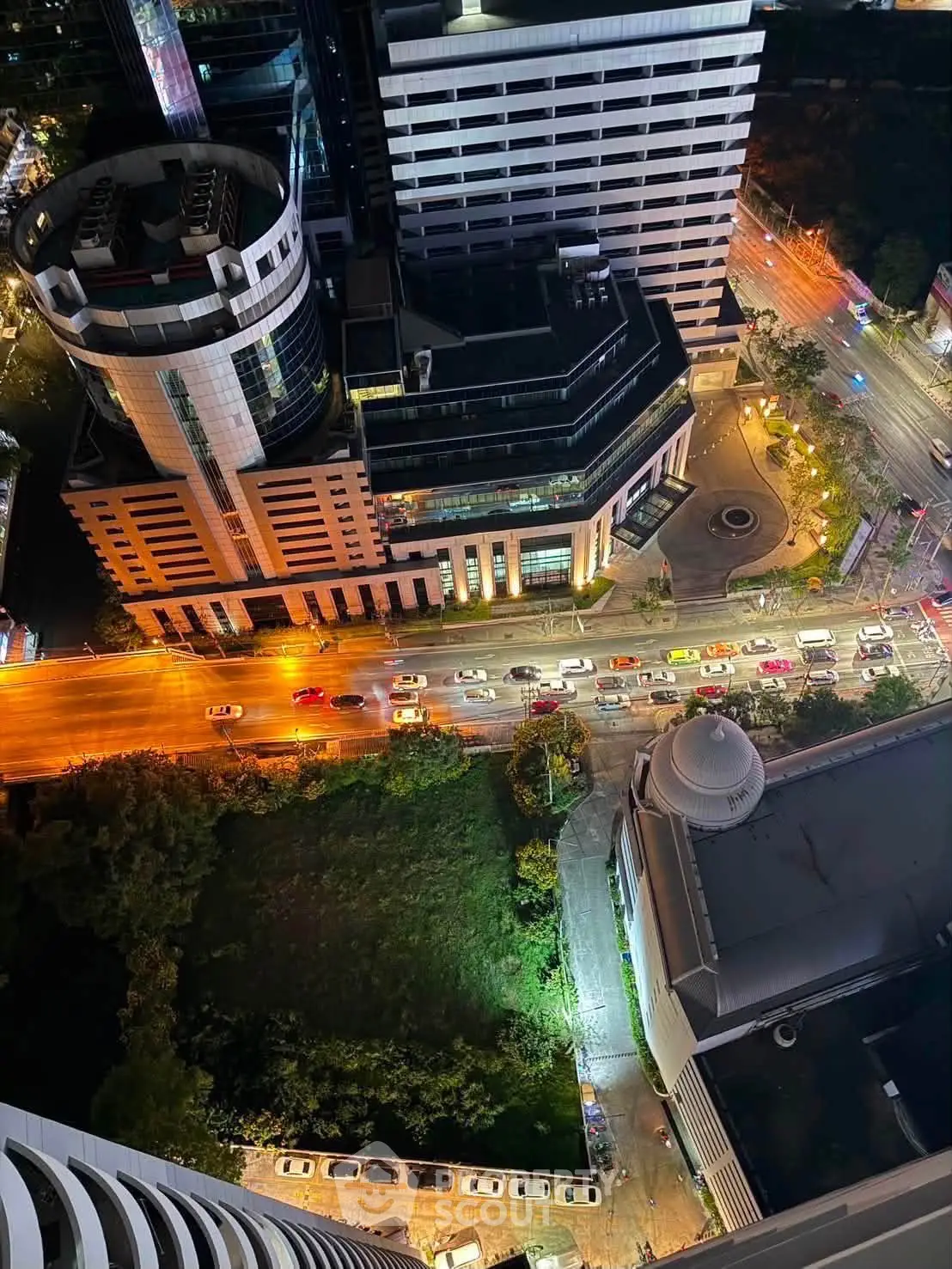 Stunning aerial view of cityscape with modern buildings and bustling streets at night, showcasing urban living.