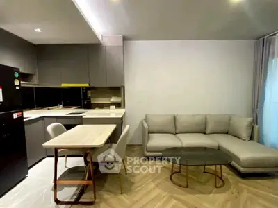 Modern open-layout kitchen and living room with stylish furniture and sleek design.