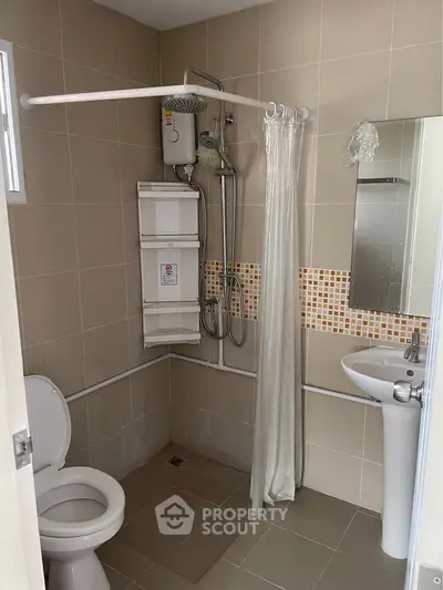 Compact bathroom with shower, toilet, and sink in modern apartment.
