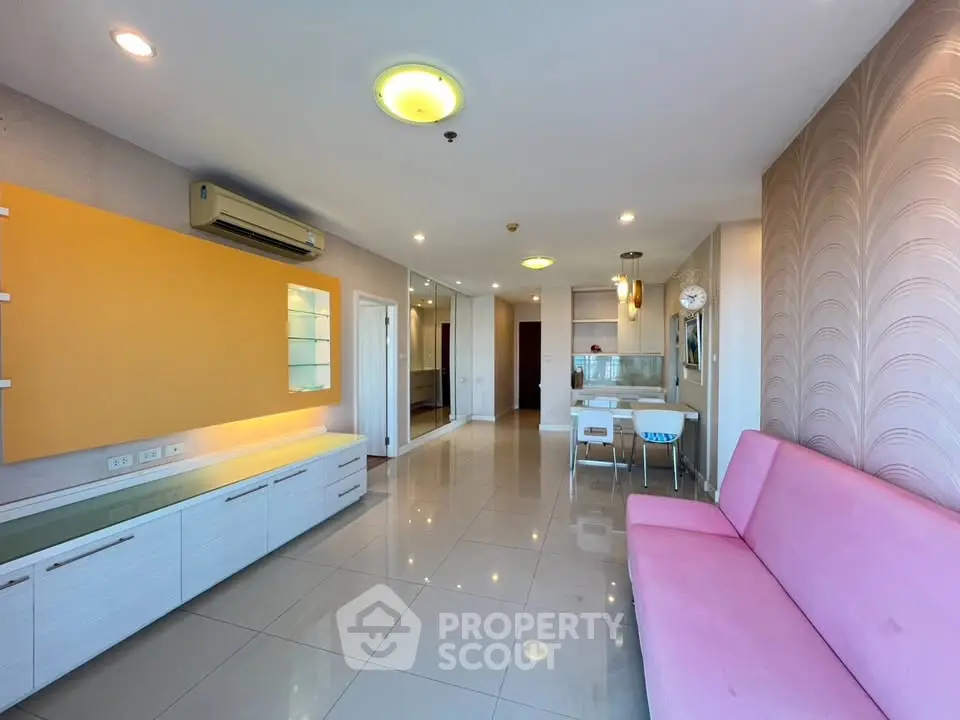 Spacious living room with modern decor and pink sofa in bright apartment