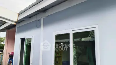 Charming single-story home exterior with modern windows and pastel walls.