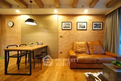 Stylish living room with leather sofa and wooden dining table, modern lighting and decor.