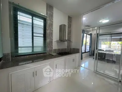 Modern kitchen with sleek design and open layout, featuring gas stove and ample natural light.