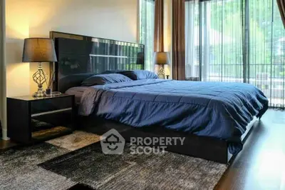 Luxurious bedroom with modern decor and large windows overlooking a serene view.