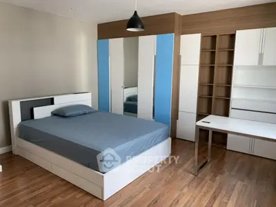 Modern bedroom with stylish furniture and wooden flooring
