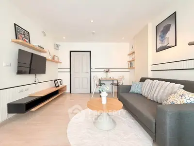 Modern living room with stylish decor, cozy sofa, and wall-mounted TV in a bright apartment.