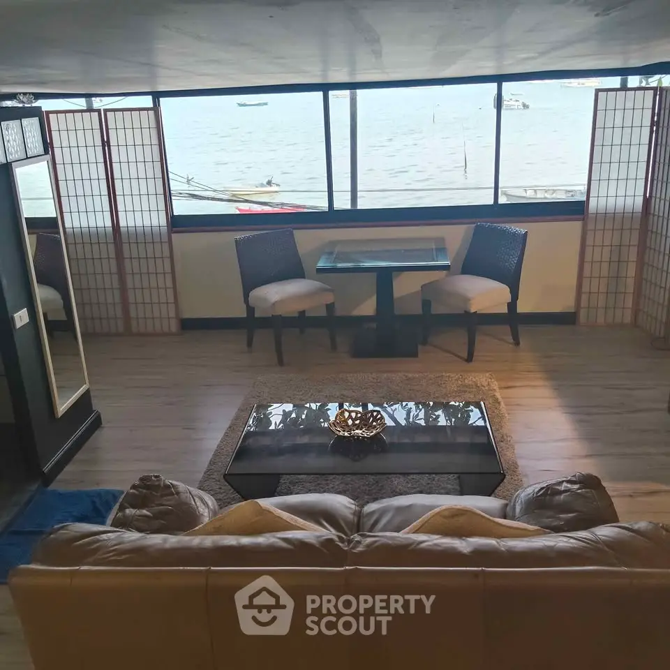 Stunning waterfront living room with panoramic sea views and elegant decor.