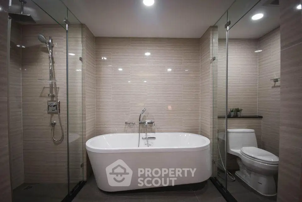 Luxurious modern bathroom with elegant bathtub and glass shower enclosure.