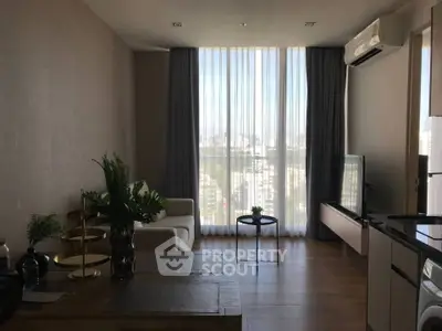 Modern living room with city view, featuring sleek furniture and large windows for natural light.