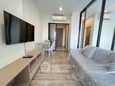 Modern living room with sleek furniture and wall-mounted TV in a stylish apartment.