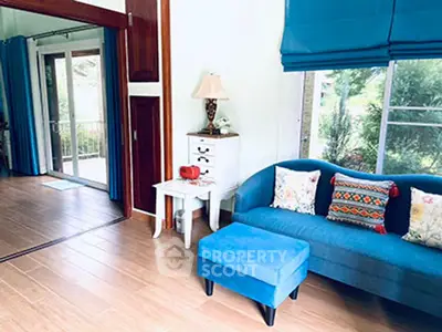 Charming living room with blue sofa and garden view, perfect for relaxation.