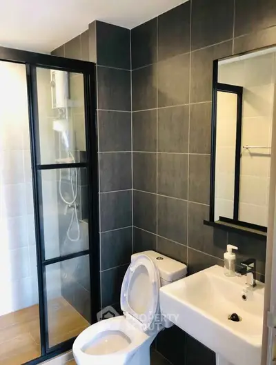 Modern bathroom with sleek design featuring glass shower and contemporary fixtures.
