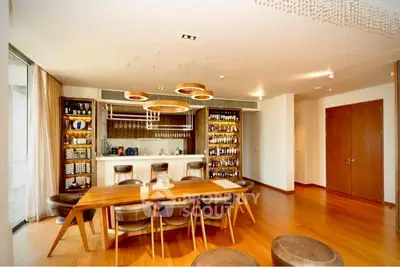 Luxurious dining room with elegant wooden table and modern lighting in upscale apartment.
