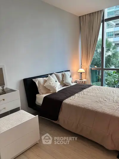 Modern bedroom with large window and elegant decor in luxury apartment.