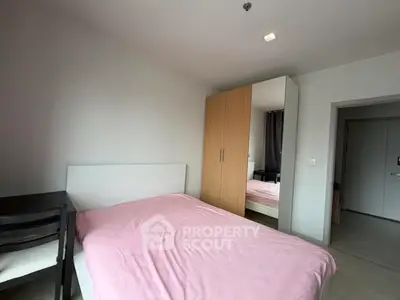 Cozy bedroom with pink bedding and mirrored wardrobe in modern apartment.