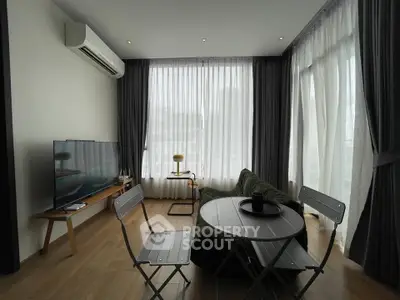 Modern living room with large windows, stylish furniture, and natural light.