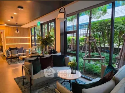 Modern living room with large windows overlooking lush garden, featuring stylish furniture and elegant decor.