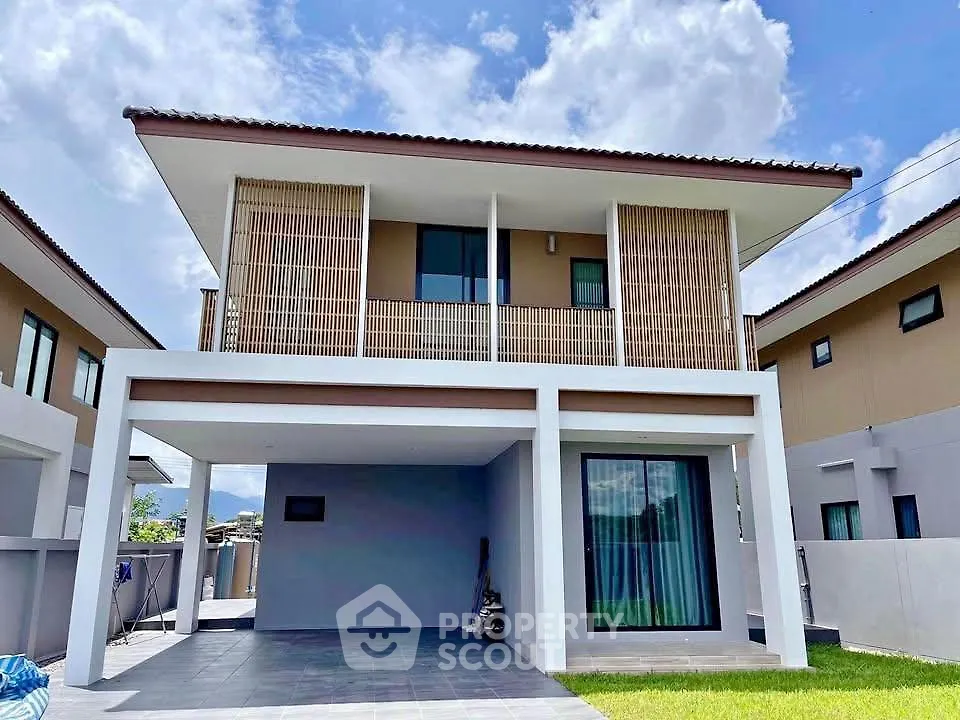 Modern two-story house with spacious carport and stylish balcony design.