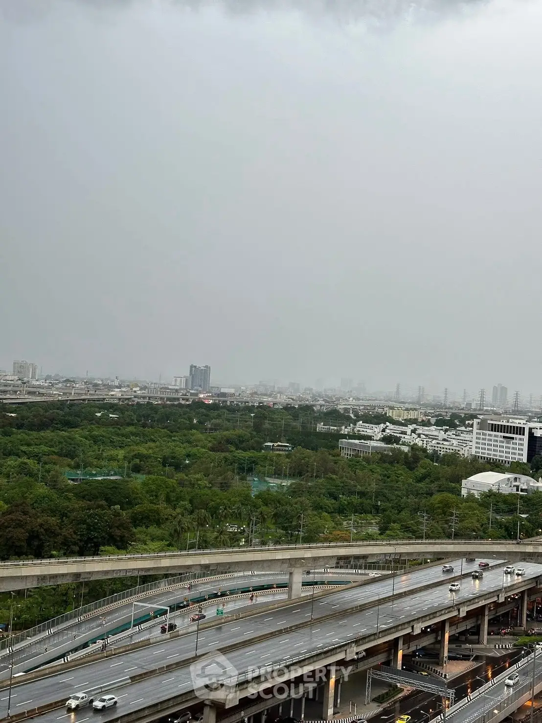 Stunning cityscape view with lush greenery and highway, perfect for urban living enthusiasts.