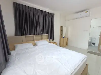 Spacious bedroom with modern decor and ensuite bathroom in a stylish apartment.