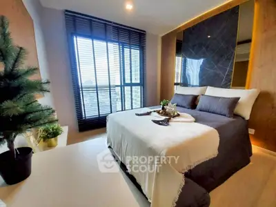 Luxurious bedroom with modern decor and large windows offering stunning city views.
