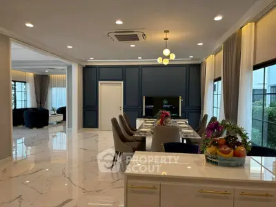 Luxurious open-plan living and dining area with elegant decor and marble flooring.