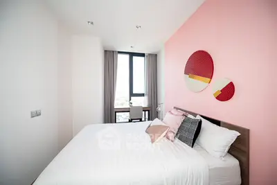 Modern bedroom with stylish decor and large window offering natural light