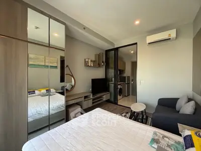 Modern studio apartment with cozy living area and sleek kitchen