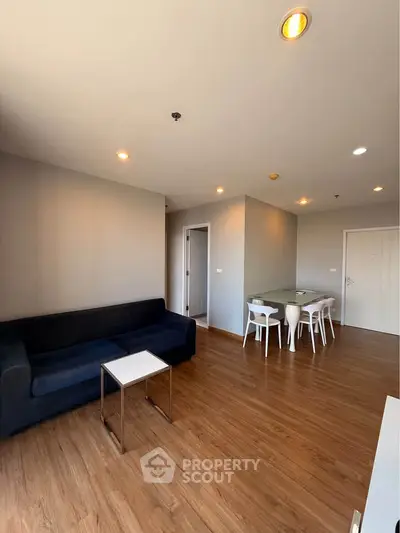 Modern living room with sleek furniture and wooden flooring in a stylish apartment.