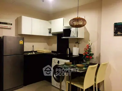 Modern kitchen with washing machine and dining area in cozy apartment