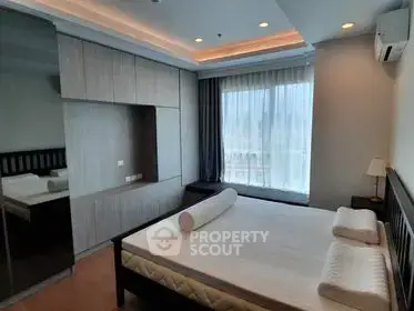 Spacious bedroom with modern design and large window offering natural light.