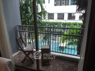 Charming balcony with pool view in modern apartment complex, perfect for relaxation and leisure.