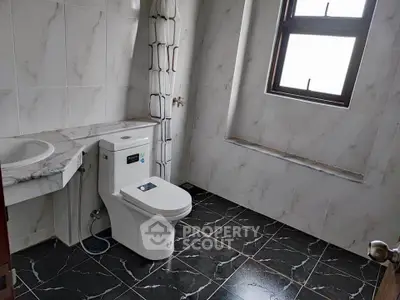 Spacious modern bathroom with elegant marble tiles and natural light