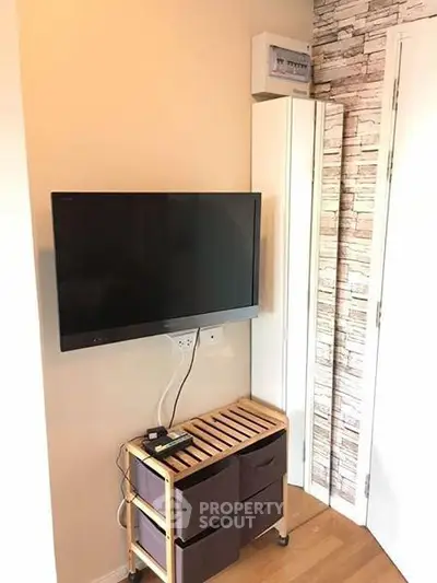 Modern living room corner with wall-mounted TV and stylish storage unit.