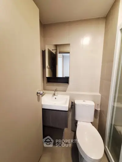 Modern bathroom with sleek fixtures and neutral tones, featuring a compact design for efficient space use.