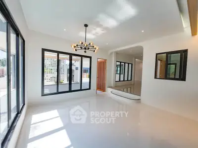 Spacious modern living room with large windows and elegant lighting