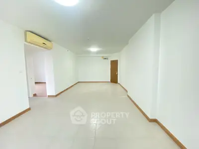 Spacious empty living room with air conditioning and tiled flooring