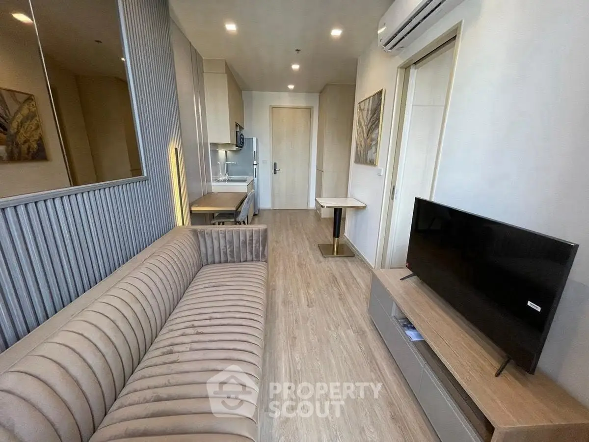 Modern living room with sleek furniture and wall-mounted TV in a stylish apartment.