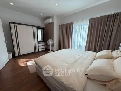 Spacious bedroom with modern decor and natural light, featuring a large bed and stylish wardrobe.
