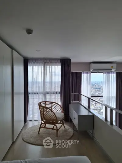 Modern bedroom with panoramic city view, featuring stylish rattan chair and sleek storage unit.