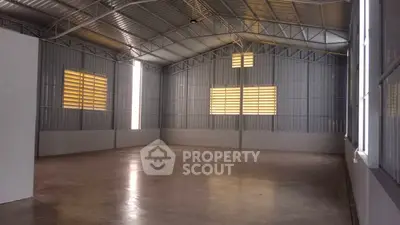 Spacious industrial warehouse with high ceilings and ample natural light.